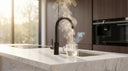 Arno boiling water tap digital variant dispensing 98°C hot water into glass cup on marble kitchen counter