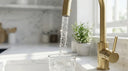 Arno brass kitchen tap dispensing water into glass, luxury instant boiling water tap, modern design