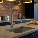 Modern kitchen with stainless steel sink and ARNO Halo boiling water tap against a brick wall
