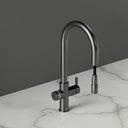 ARNO Halo brushed gunmetal instant boiling water tap side view with pull out spray head on marble countertop